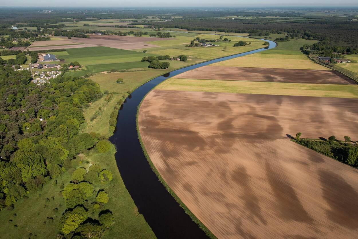 Akkerland met een meanderende rivier ertussen