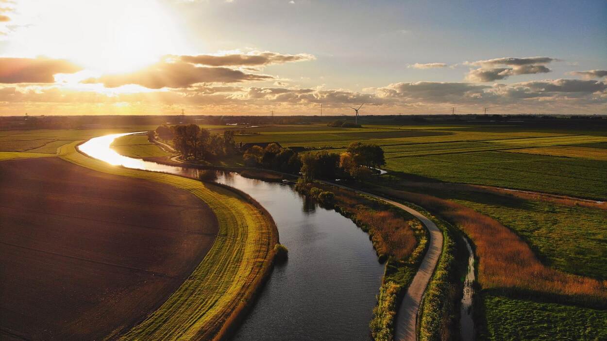 Akkerland met een meanderende rivier ertussen